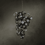 Conjunto de tuercas metálicas suspendidas formando una composición artística sobre fondo oscuro texturizado